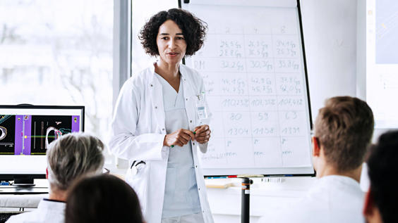Doctor standing in front of group with chart